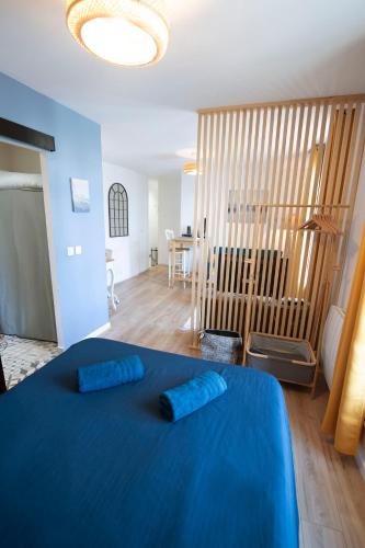 - une chambre dotée d'un lit bleu avec deux oreillers bleus dans l'établissement Le Cosy & Boisé de Pontoise, à Pontoise