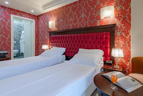 a bedroom with two beds and a red headboard at La Paloma Blanca Hotel in Sciacca