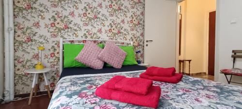 a bedroom with a bed with green and red pillows at Floral Tribute Studio in Kavála