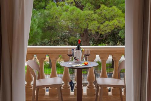 a table and chairs on a balcony with a window at La Paloma Blanca Hotel in Sciacca