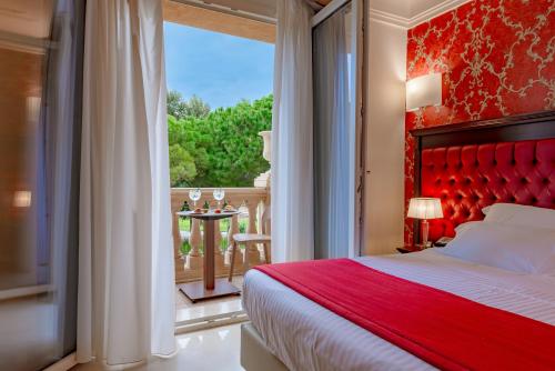 a bedroom with a red headboard and a large window at La Paloma Blanca Hotel in Sciacca