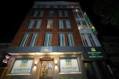 a tall brick building with signs on the front of it at Hampton By IC's in Noida