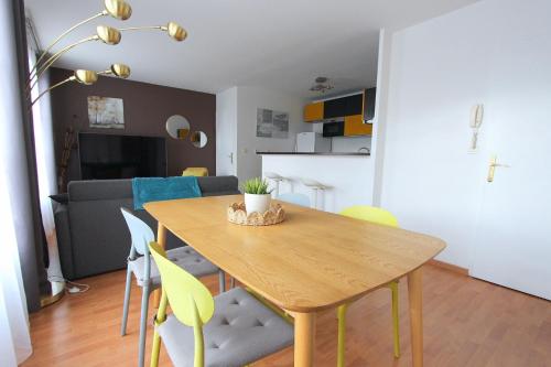 - une salle à manger et un salon avec une table et des chaises en bois dans l'établissement Tage1 - Val d'Europe et Disneyland Paris, à Serris