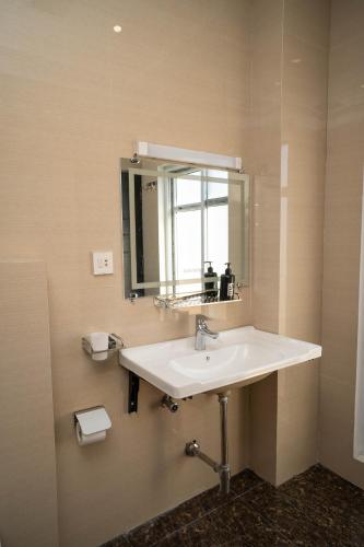 een badkamer met een witte wastafel en een spiegel bij Just Move Premium 2BR Suite, Near ISB Int'l AIRPT in Islamabad