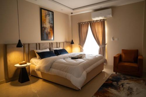 a bedroom with a large bed and a chair at Just Move Premium 2BR Suite, Near ISB Int'l AIRPT in Islamabad