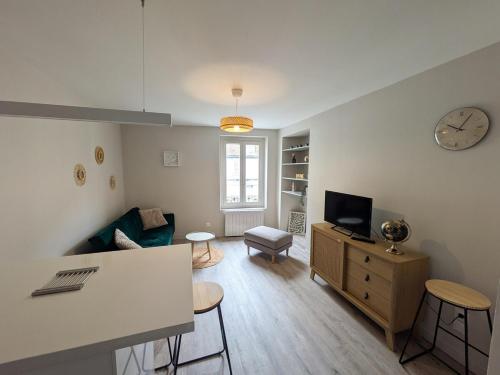 a living room with a couch and a clock on the wall at Appartement dans le quartier médiévale proche centre-ville ! in Bourges