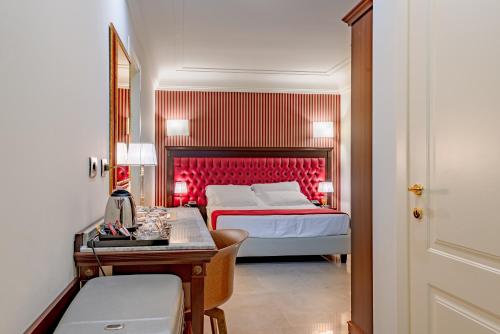 a bedroom with a bed and a desk and a mirror at La Paloma Blanca Hotel in Sciacca