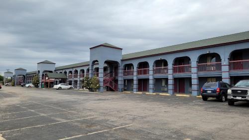 a building with cars parked in a parking lot at Americas Best Value Inn Frost Bank Center in San Antonio