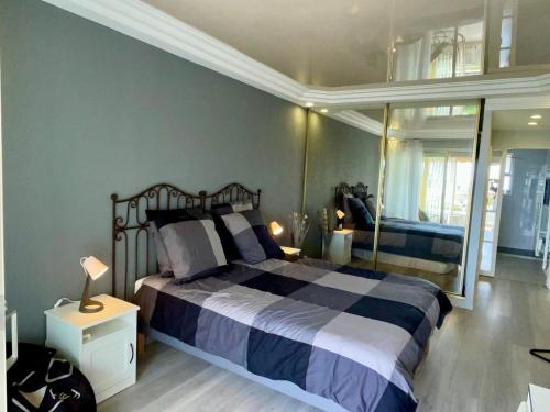 une chambre avec un grand lit et un miroir dans l'établissement Bel appartement Vue sur la Marina Classé 3 étoiles, à Villeneuve-Loubet