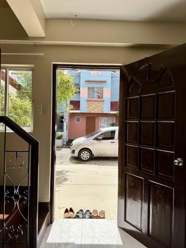 a door to a house with a pair of shoes outside at Abode86 Transient House-PGT in Gabi
