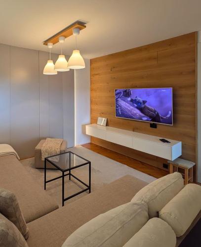 a living room with a flat screen tv on a wall at Superbia Osijek - SELF CHECK-IN in Osijek
