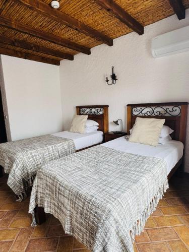 two beds sitting next to each other in a room at Zé Inácio - Alojamento e Restaurante in Porto Covo
