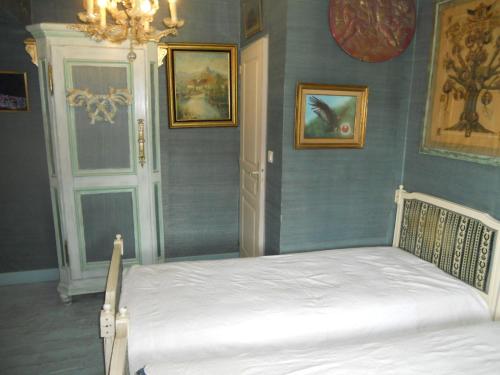 a bedroom with a bed in a room with blue walls at Ferme de la Dorvallière in Cavagnac