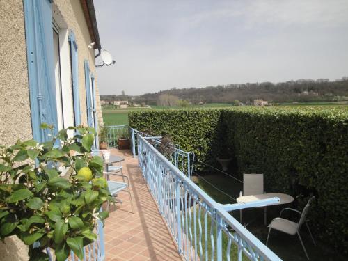 een balkon met tafels en stoelen en een heg bij Chez Nanie in Mane