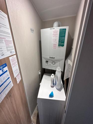 une chambre à l'hôpital avec une machine au-dessus des toilettes dans l'établissement Caravan Selsey, à Selsey