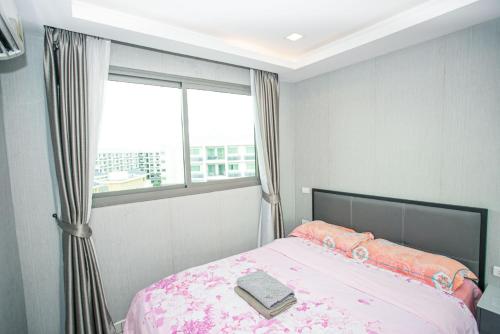 a bedroom with a pink bed with a window at Arcadia阿卡迪亚二期 in Pattaya South