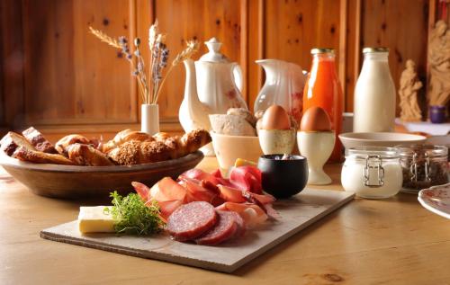 un tavolo con un piatto di cibo e una ciotola di pane di Der Hof - Perntal Retreat a Gais