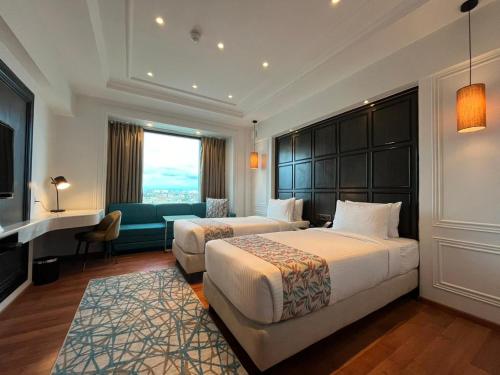 a hotel room with two beds and a couch at Hotel SOOT in Kolkata