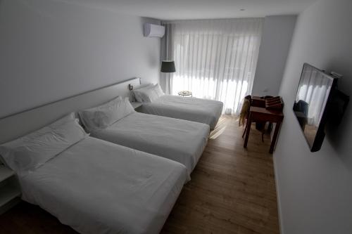 a hotel room with two beds and a mirror at Hotel hcp in Calella de Palafrugell