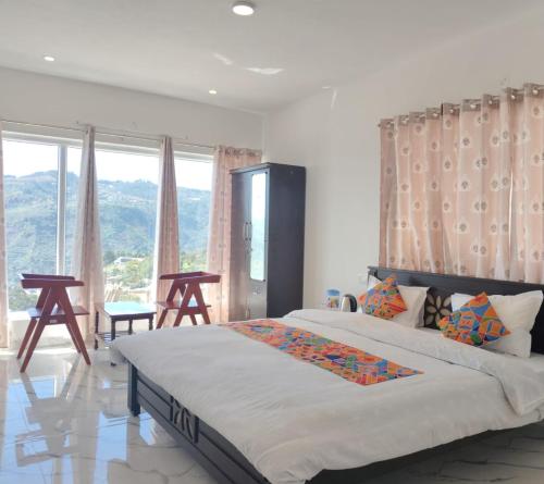 Un dormitorio con una cama grande y una ventana grande. en THE DEW stay, en Kodaikanal