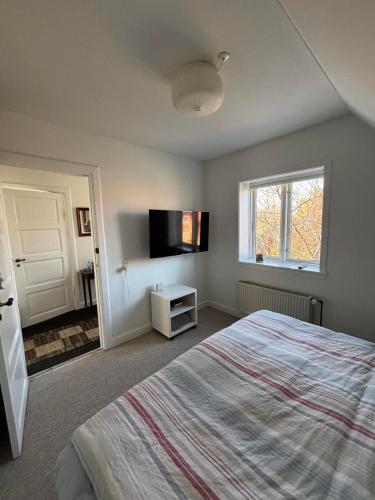 a bedroom with a bed and a flat screen tv at Kleiters Bed & Kitchen in Copenhagen