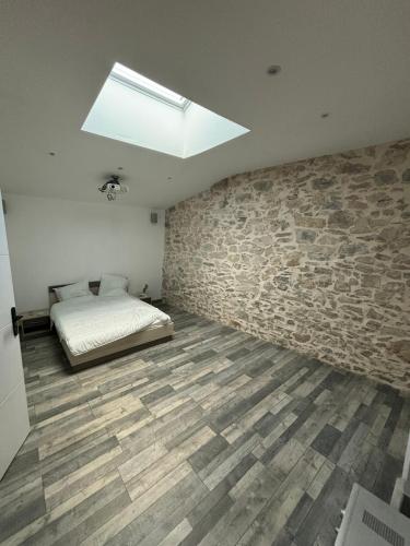 une chambre avec un lit et un mur en pierre dans l'établissement Maison Provençale, Piscine, Soleil, Barbecue et Pétanque, à Saint-Gervasy