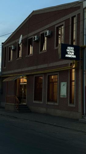 a building with a sign on the front of it at Aero Hotel Tour Armenia in Pʼarakʼar
