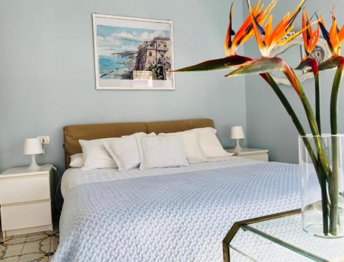 a bedroom with a bed and a vase with a flower at Large family appartament with pool in Sorrento