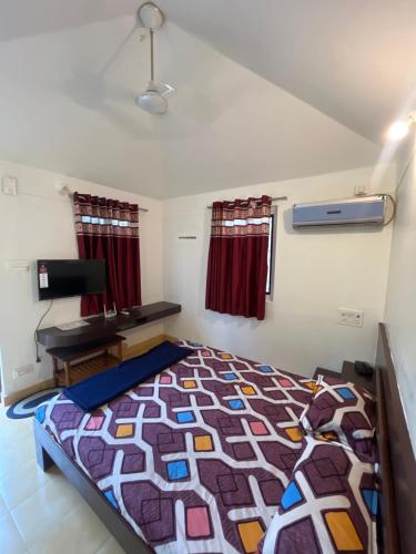 a bedroom with a bed and a desk in it at Amrapali Resort in Top