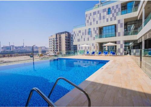 a large swimming pool in front of a building at Luxury Canal View Apartment Near Yas Island DABAS1 in Abu Dhabi