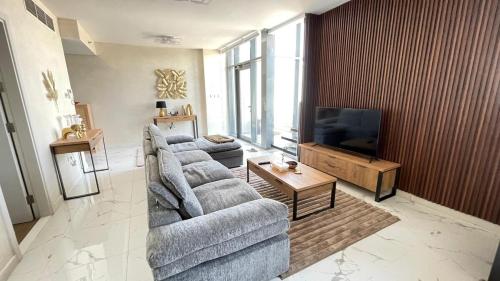 a living room with two couches and a flat screen tv at Luxury Canal View Apartment Near Yas Island DABAS1 in Abu Dhabi