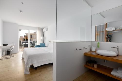 a white bedroom with a bed and a sink at Hotel hcp in Calella de Palafrugell