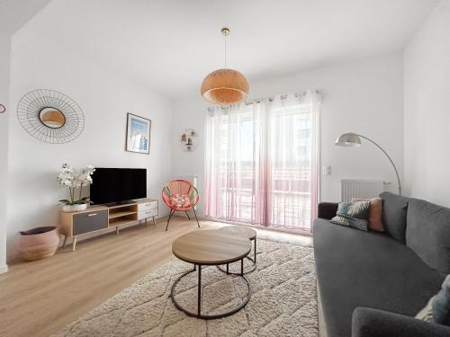 un salon avec un canapé et une table dans l'établissement Appartement Cosy Avec Grande Terrasse, à Dunkerque