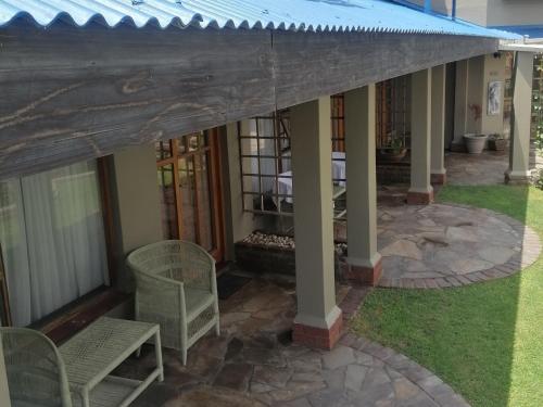 a house with a porch with chairs and a patio at 22 on Main Guesthouse Walvis Bay in Walvis Bay