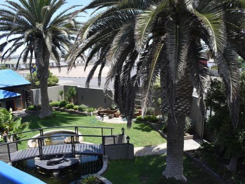 a view from the balcony of a resort with palm trees at 22 on Main Guesthouse Walvis Bay in Walvis Bay