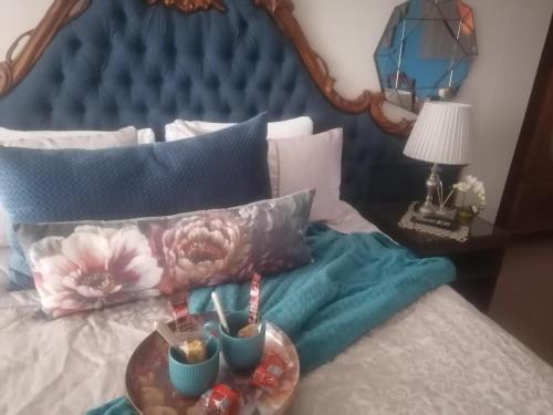 a bed with a blue head board with a plate on it at 22 on Main Guesthouse Walvis Bay in Walvis Bay