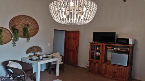 a living room with a table and a chandelier at 22 on Main Guesthouse Walvis Bay in Walvis Bay