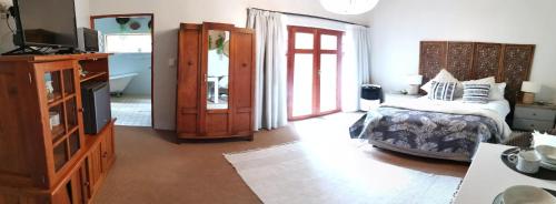 a bedroom with a bed and a television in it at 22 on Main Guesthouse Walvis Bay in Walvis Bay