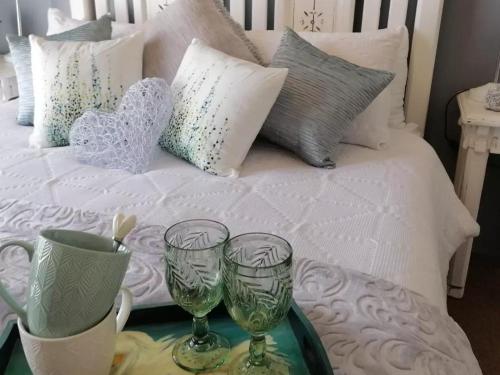 a bed with two wine glasses on a tray at 22 on Main Guesthouse Walvis Bay in Walvis Bay