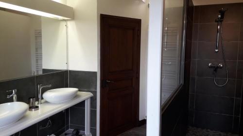un bagno con due lavandini e una doccia di Lalaurie Groupe a Sauveterre-la-Lémance