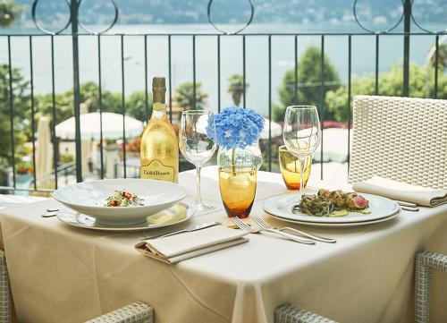 a table with plates of food and a bottle of wine at Hotel Belvedere Ranco in Ranco