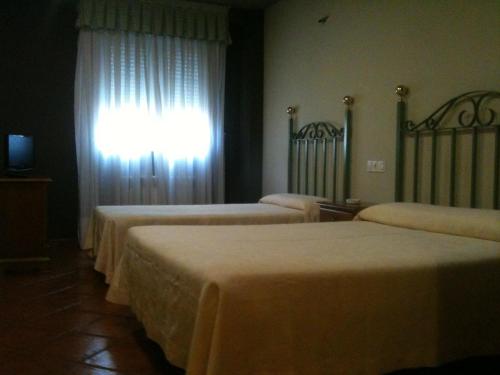 a room with three beds and a window at Hotel El Balcón in Avilés