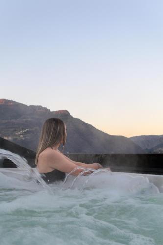 a woman sitting in a hot tub in the water at Casa Martina in Zogno
