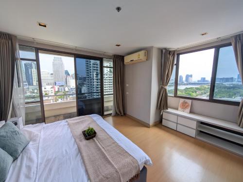 a bedroom with a bed and large windows at High Floor Great View 2BR 2BA 3 mins to Nana BTS in Bangkok