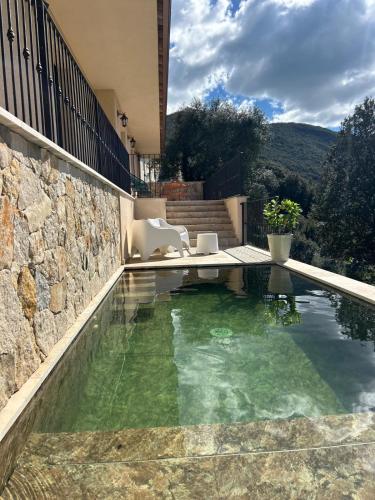 - une piscine avec une table et des chaises dans une maison dans l'établissement La villa Orso, piscine chauffée , vue panoramique, à Sollacaro
