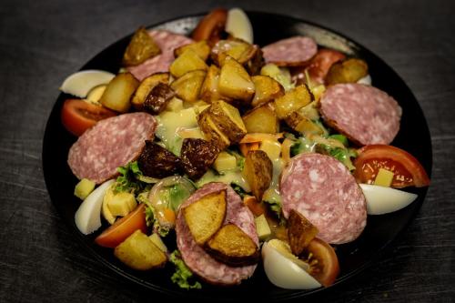 a plate of food with sausage potatoes and vegetables at Auberge du château de Joux in La Cluse et Mijoux