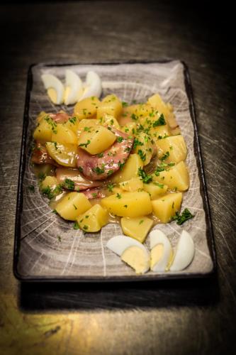 a plate of food with potatoes and onions on a table at Auberge du château de Joux in La Cluse et Mijoux