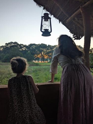 two young girls are looking out at a field at Ethili Lake view & Safari Camp in Wellawaya