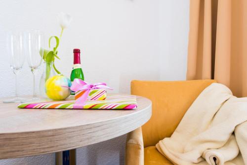 a table with a chair and a bottle of wine at Hotel Boddenhus Garni in Zingst