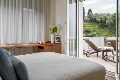 a bedroom with a bed and a view of a balcony at Doria Park Hotel in Lerici